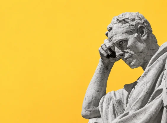 Statua classica in atteggiamento riflessivo su fondo giallo